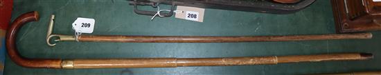 An umbrella cane and a whistle handled cane, stamped Orchard